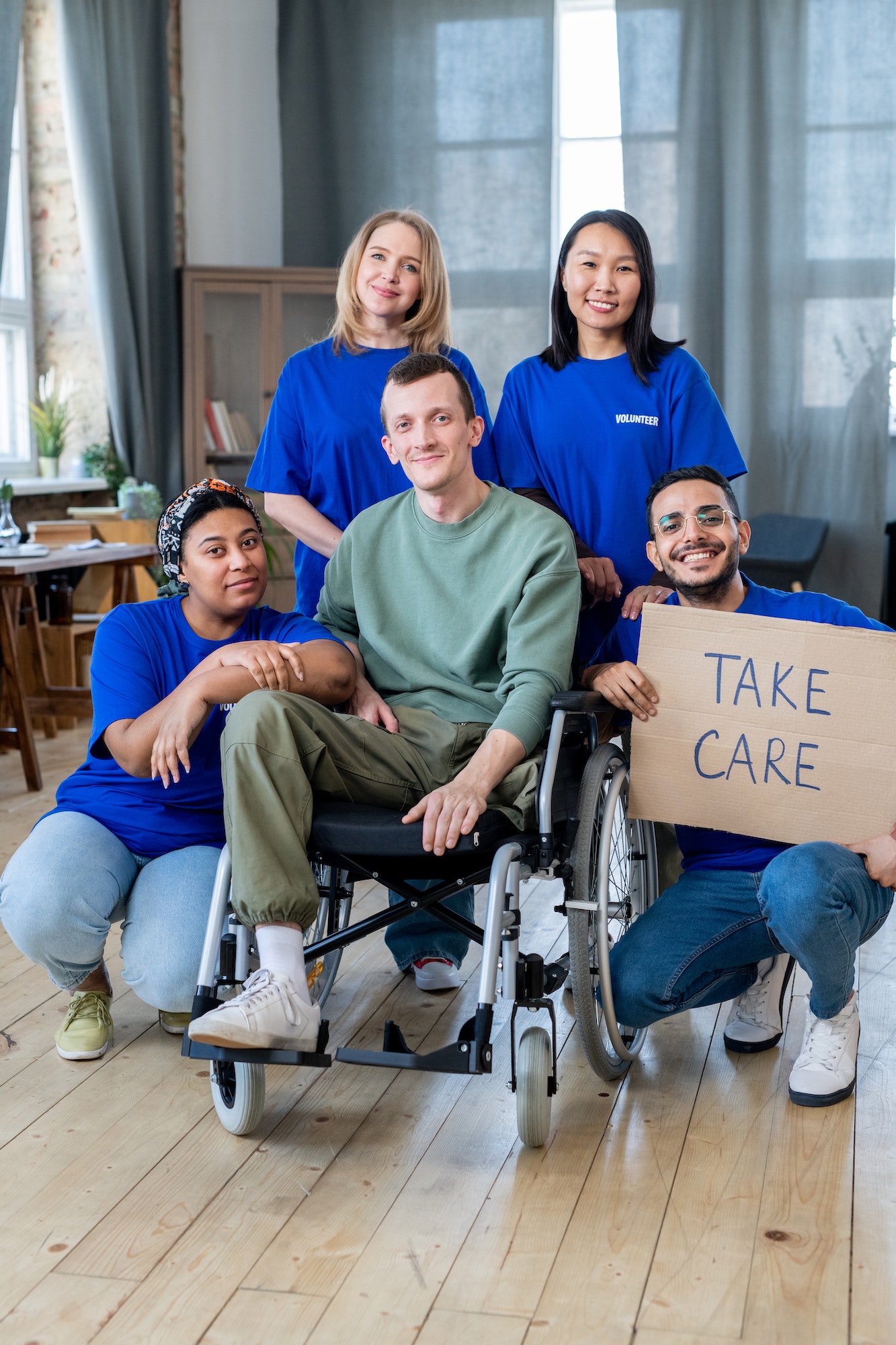 A group of volunteers and man in wheelchair posing for a photo