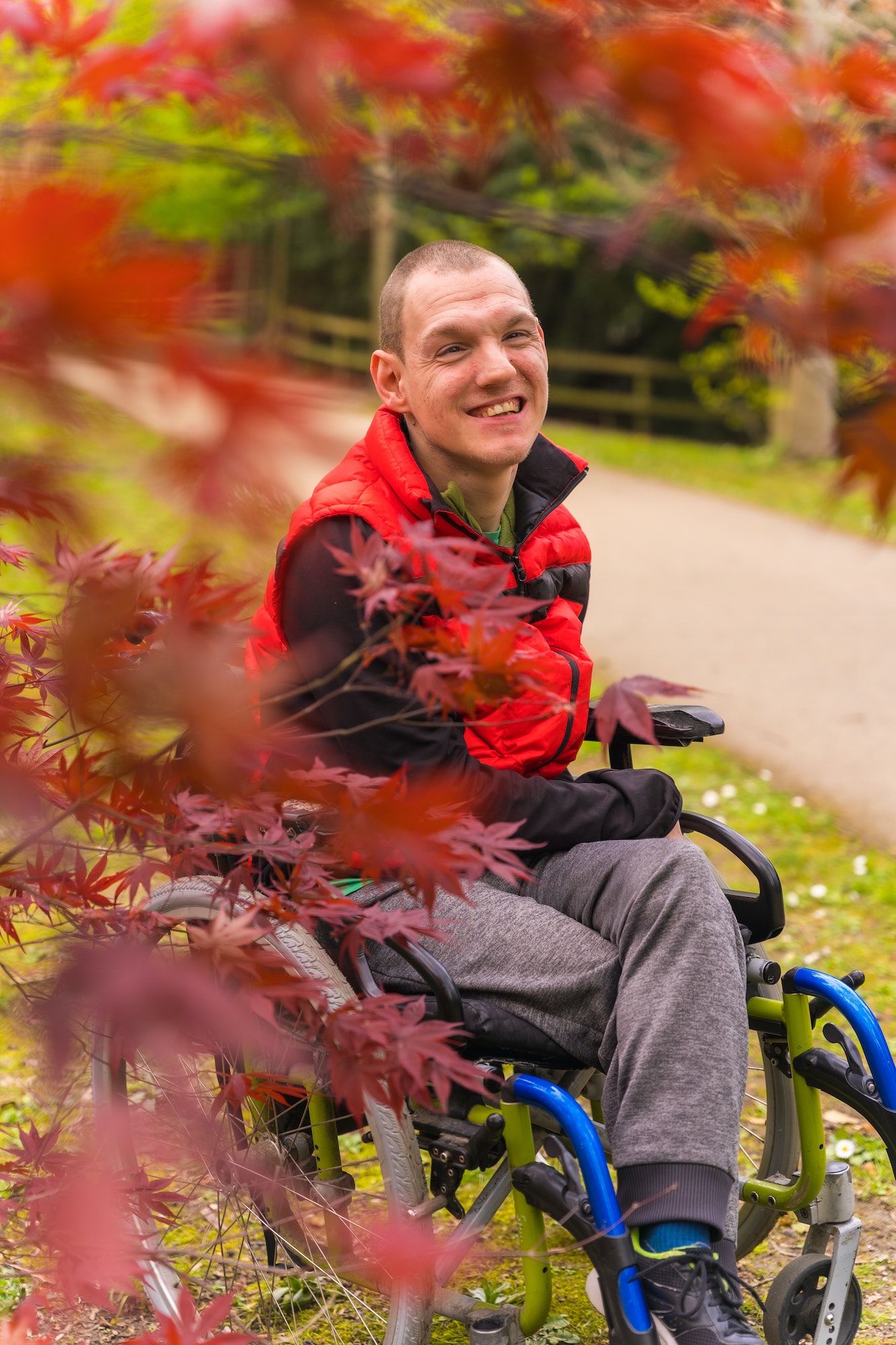 Sitting in the wheelchair next to red leaves